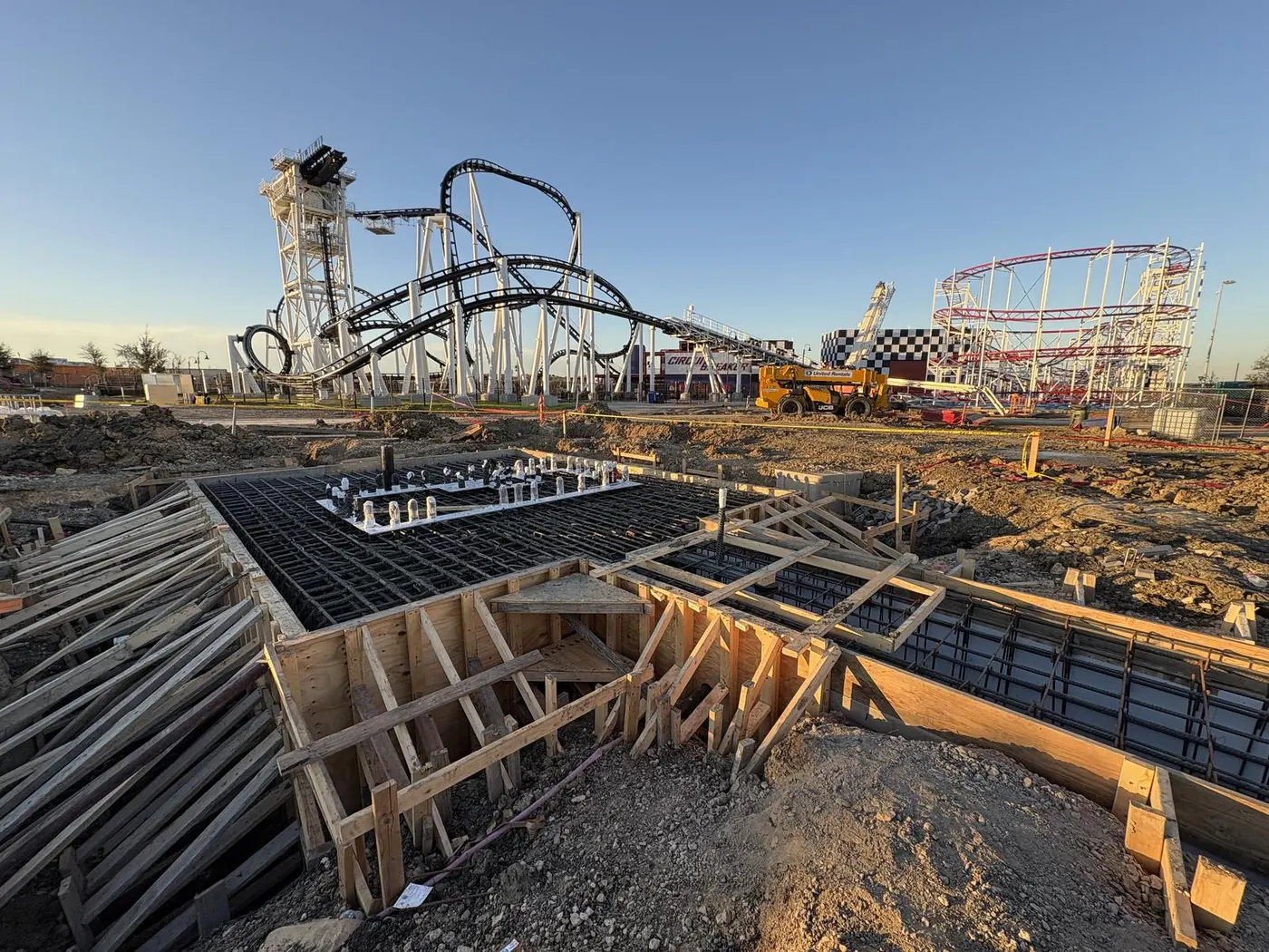Attraction foundation formwork under construction with COTALAND's roller coasters rising in the background