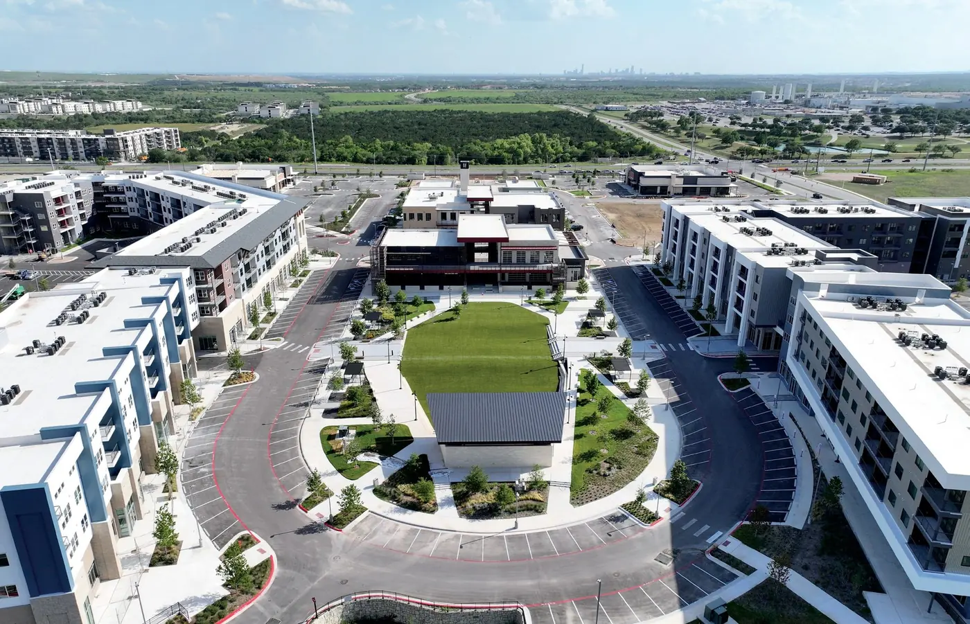 Aerial view of East Village Green, with the central lawn and amphitheater surrounded by new buildings